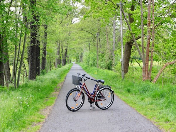 Zwei Fahrräder der Spreewald Pension Spreeaue stehen an einem Fahrradweg direkt neben der Pension